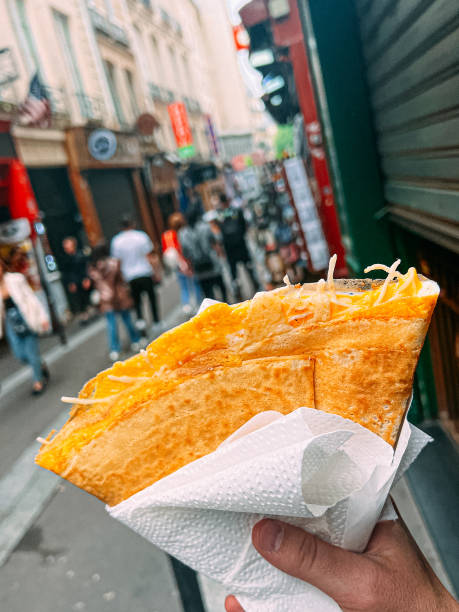 istock Young Man's Hand Holding a Folded Egg & Cheese Crepe in Paris 2015713490