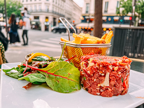 French Steak Tartare, Fries, and Green Salad in Paris, France on a calm Summer Evening