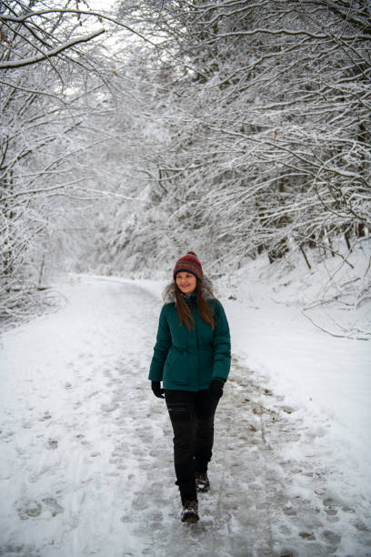 istock Winter Trek: Woman Walking on a Snowy Forest Path 2015716606