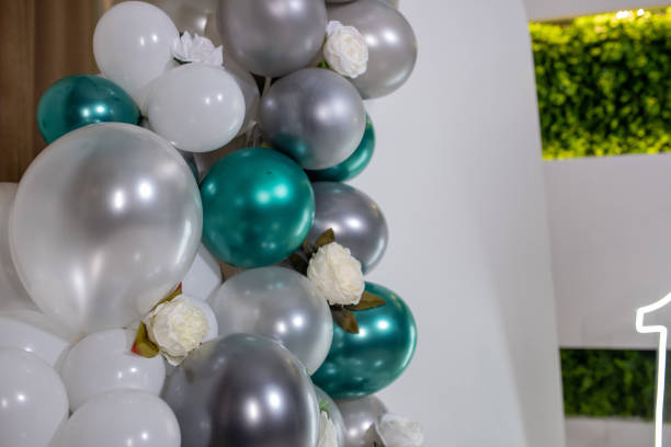 Arch decorated with green, grey, white balloons and flowers