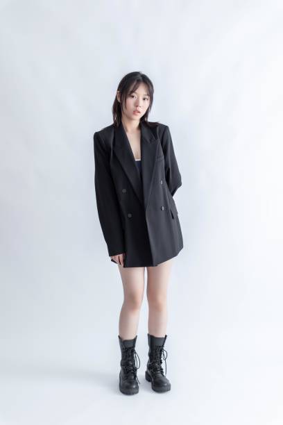 istock Asian young woman in black suit and boots posing in studio 2015745952
