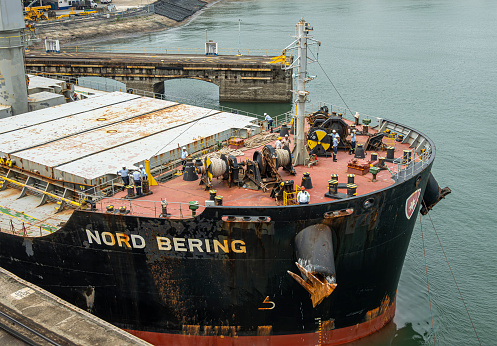 Panama Canal, Panama - July 24, 2023: Leaving Gatun Locks, workers on bow of Nord Bering bulk carrier.