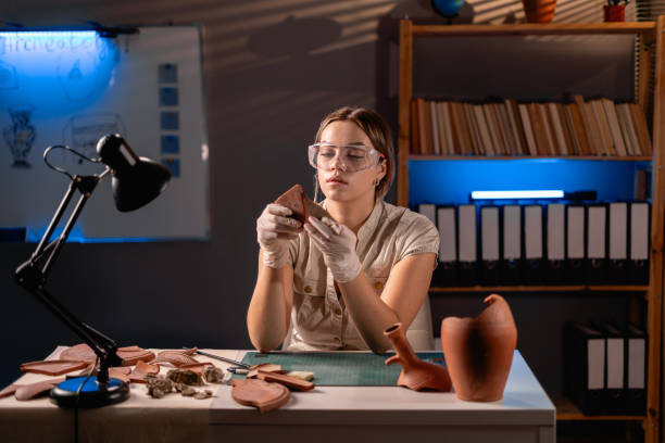 istock Female archaeologist studying an ancient vase working late at night in her office 2015764216