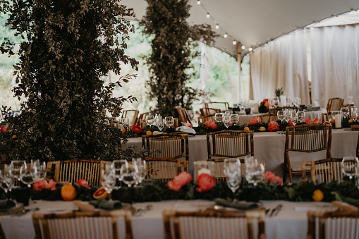 Detail of table for eating at a wedding banquet. Elongated table with beige, green, orange and pink tones. Vertical photo with leak at the top.