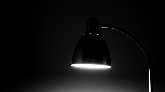 The floor lamp shines in the dark. Single lamp in the dark. Lamp night black and white.