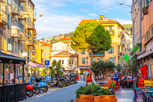 A colorful section of Vieux Nice, the historic old town, full of sidewalk cafes and shops in the Mediterrean seaside city of Nice, France, along the Cote d'Azur, French Riviera.