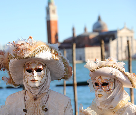  Venice, Italy- February 8, 2015. A couple disguised in Venetian costumes pose in front of Bridge of Sighs during the Venice Carnival days. Shot in St. Mark's Square. The Carnival of Venice is a annual festival held in Venice and is one of the most popular and appreciated carnival in the world.