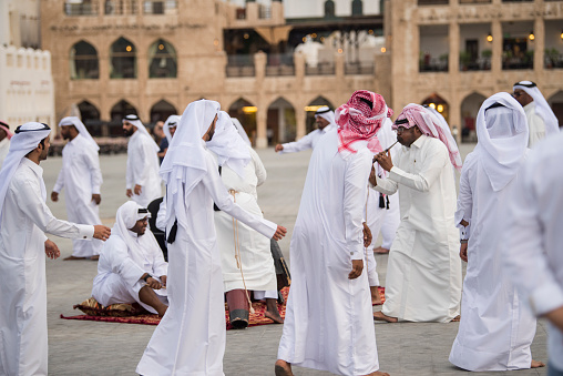 Doha, Qatar - April 22,2023: The performance of traditional Qatari music and dance is performed by local people in old bazaar market Souk Waqif.
