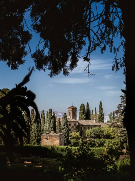 tower of the church iglesia de santa maria de la encarnacion in the alhambra, granada, from the gardens of generalife - catedral de la encarnacion imagens e fotografias de stock