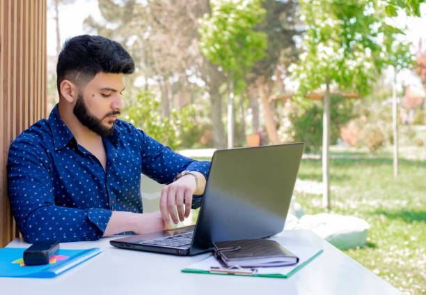 istock Handsome asian freelancer sitting at table, working outdoors. 2015870954