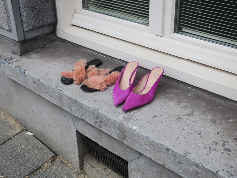 two pair of ladies shoes left on the windowsill