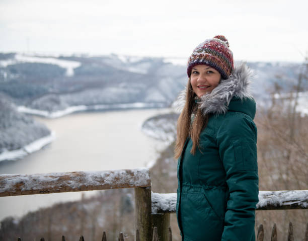 Smiling Woman Overlooking a Snowy River Landscape
