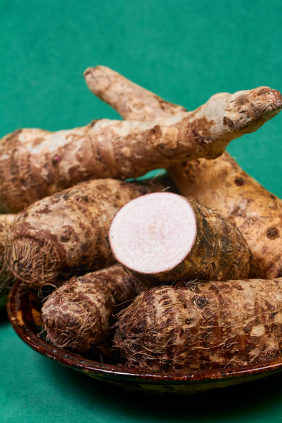 closeup of taro root vegetable, eddo malanga, green background - chinese eddo zdjęcia i obrazy z banku zdjęć