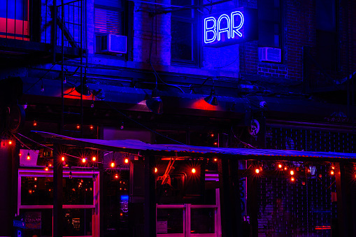 Exterior of bar on the Lower East Side In New York at night with colorful illuminated lights