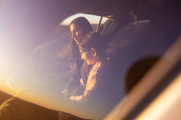 istock Young mother and her daughter having fun in their  car. 2015922751