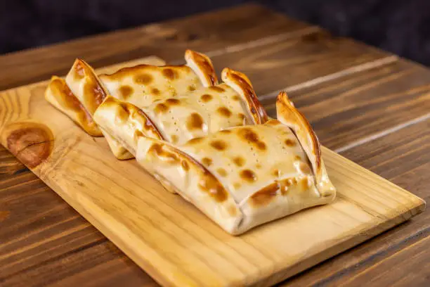 Photo of Chilean empanadas variety. Chile Food background. Fresh ingredients on wood. Selective Focus. Fiestas Patrias Chile.