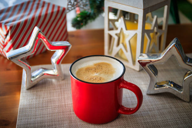 Hot coffee in red mug with a heart shape foam.