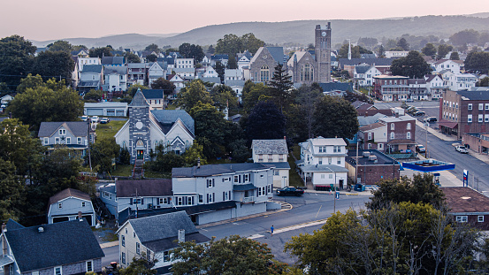 Main streets of Lehighton town in Pennsylvania at dusk. Row houses and Zion United Church of Christ rise above the small American town