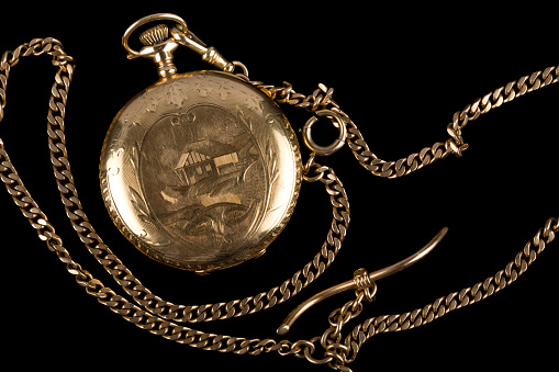 Antique pocket watch from 1917 on black background.