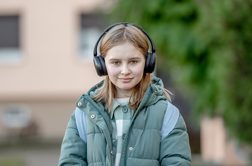 Portrait Of 10-Year-Old Girl On Street In Spring, Child In Headphones