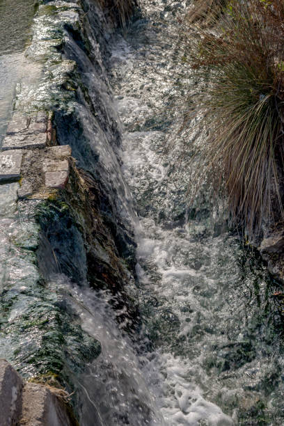 The waters of natural and healing spring Thermopylae flow through rocks and rocks coming out of the ground on an autumn day (Central Greece).