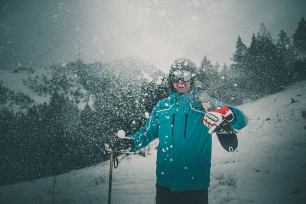Skier female portrait in safe ski helmet and goggles with picturesque snowy Tatry mountains background.
