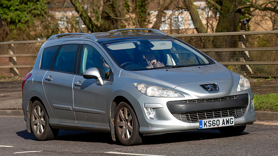 Milton Keynes,UK-Feb 16th 2024:  2011 silver diesel engine Peugeot 308 car  driving on an English road