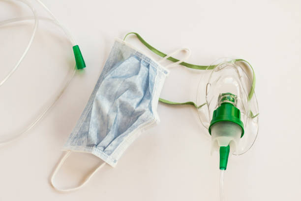 istock Oxygen mask and three-ply hygienic mask on white surface 2016243589