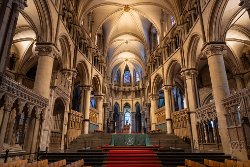 Main altar of Canterbury Cathedral among luxurious gothic architectural details. Stunning interior with vaulted ceiling and stained glass windows. Beautiful historical building of religious importance