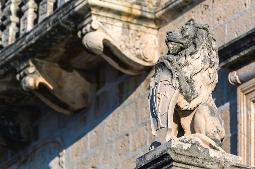 Stone lion statue with heraldic shield in front of municipal building in Perast town, Kotor Bay, Montenegro
