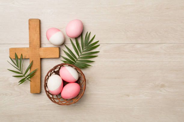 istock Pink Easter eggs with cross and leaves on wooden background, top view 2016260753