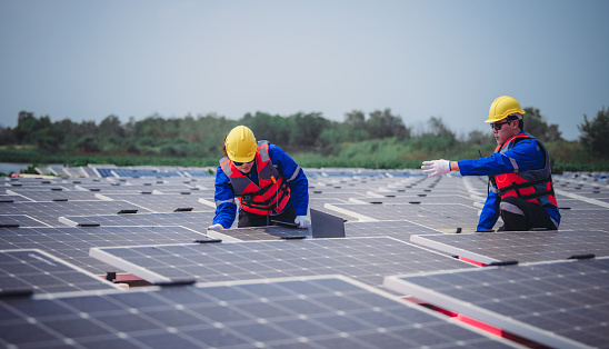 Software engineers collaborate, discuss ways to enhance a smart energy analytics app for floating solar operation. Real-time monitoring optimizes data usage, analyzes efficient consumption insights.