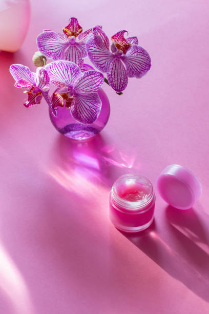 istock lip balm with orchid in glass vase on pink background 2016372345