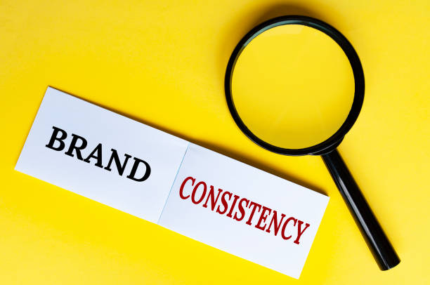 istock Brand consistency text on white notepad with magnifying glass. Building your brand concept 2016409417