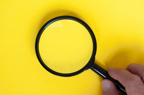 istock Top view of magnifying glass on yellow background with customizable space for text. 2016409932