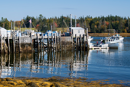 Owl's Head, USA - October 14, 2021. Pier at Owl's Head with people boarding fishing boat, Maine, USA