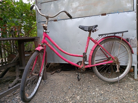 A pink bicycle was parket in front of the shop