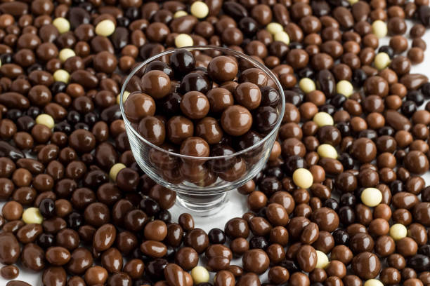 Dark and brown chocolate balls background with glass candy bowl