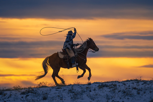 Horseback riding on a Wyoming horse ranch in the winter on a rural landscape.