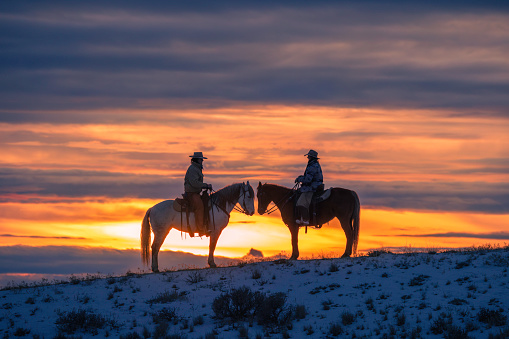Horseback riding on a Wyoming horse ranch in the winter on a rural landscape.