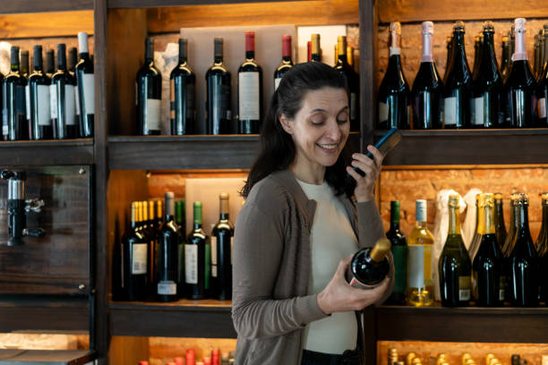 istock Caucasian woman at a winery buying a wine and calling someone on speaker phone while reading the label 2016551573
