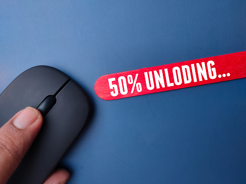Wireless mouse and colored stick with the word fifty percent unloading on a blue background