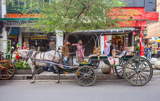 Andong on Jalan Malioboro, Jogjakarta, Indonesia. Andong (Horse Cart) is one of the traditional means of transportation used to serve tourists in Maliboro street area.