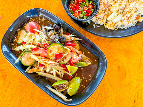 Spicy papaya salad or Somtum in Thai language serving on the table