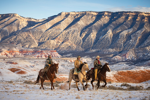 Horseback riding on a Wyoming horse ranch in the winter on a rural landscape.