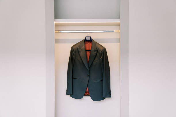istock Groom black jacket hangs on a hanger in a white sliding wardrobe in the room 2016708970