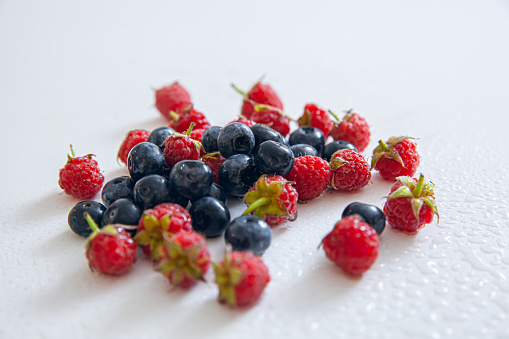 group of fresh blueberries and raspberries isolated on white background