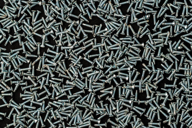 Self-tapping screws on a black background. Consumable material for fastening
