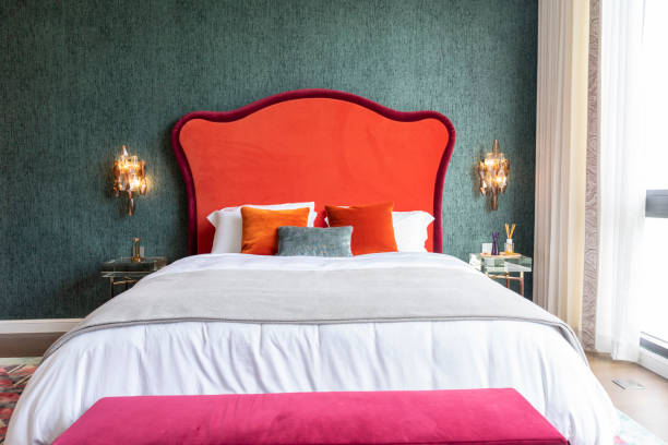 istock Modern luxurious red tone bed with crystal wall lamp in interior. 2016929826