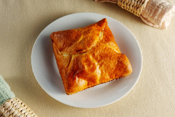 istock Delicate Delights: A Flaky Puff Pastry Placed Elegantly on a Gleaming White Plate 2016985758
